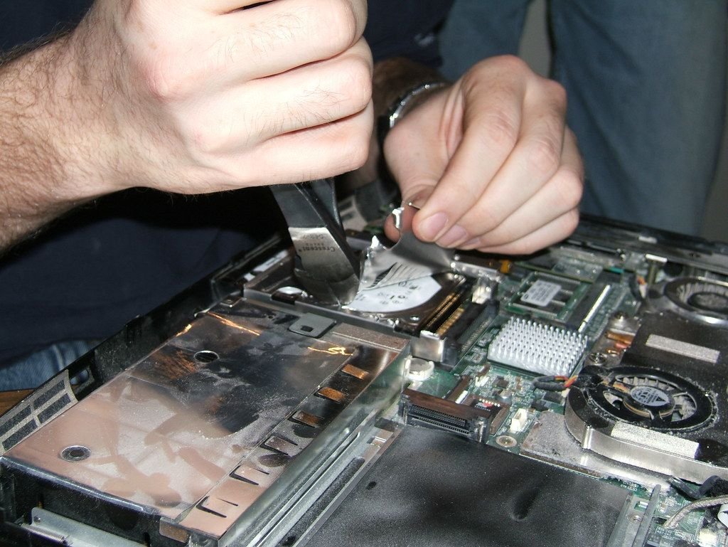 Technicians repairing laptops in a workshop